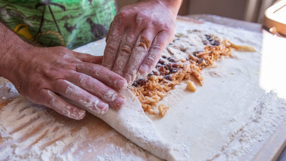 Štrúdl balíme tak, že nejprve ohneme spodní díly těsta, aby se náplň nedostala ven | foto: Martin Čuřík Štrúdl balíme tak, že nejprve ohneme spodní díly těsta, aby se náplň nedostala ven